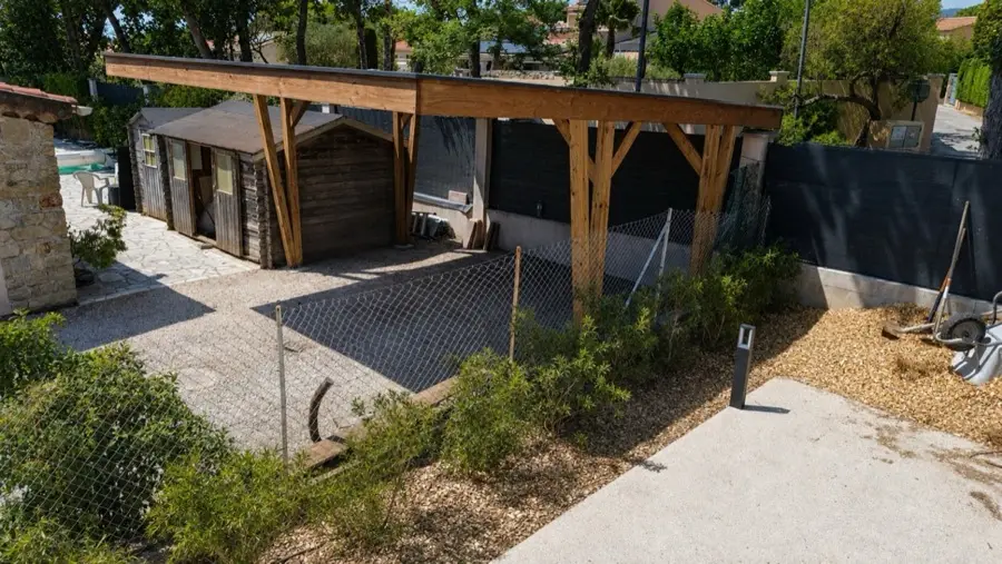 Carport en bois massif posé par l'atelier Signature 36, poteaux et jambes de force apparents